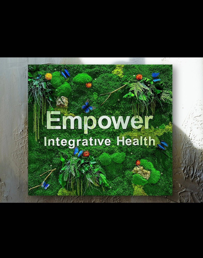 Moss wall with 'Empower Integrative Health' text on a textured white background